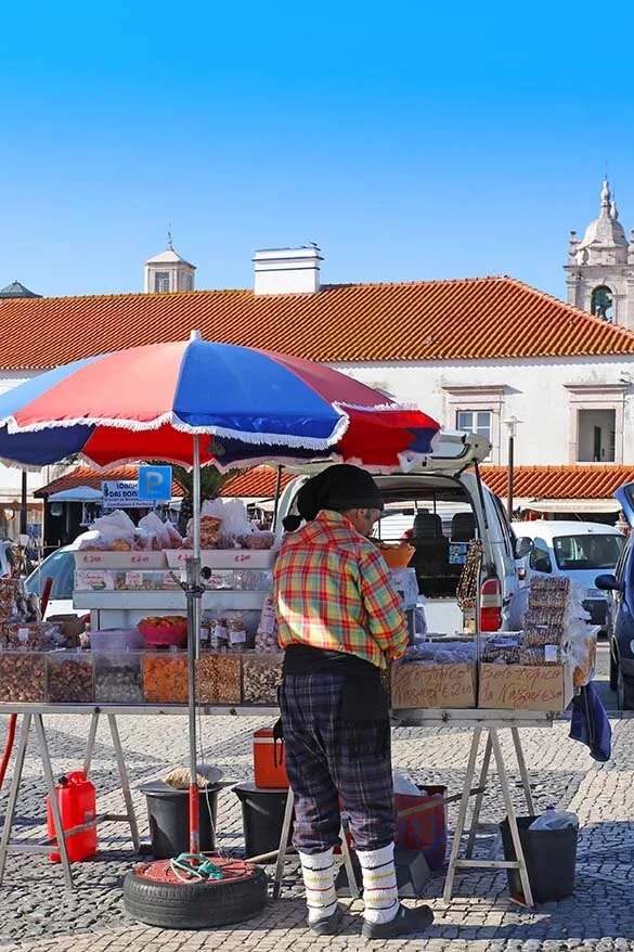 Local salesman in traditional clothing at the market in O Sitio district in Nazare Portugal