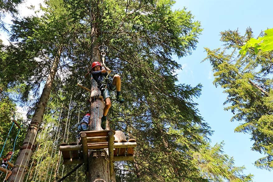 Kids ziplining in Bichlbach kletterwald - adventure park in Tiroler Zugspitz arena in Tyrol Austria