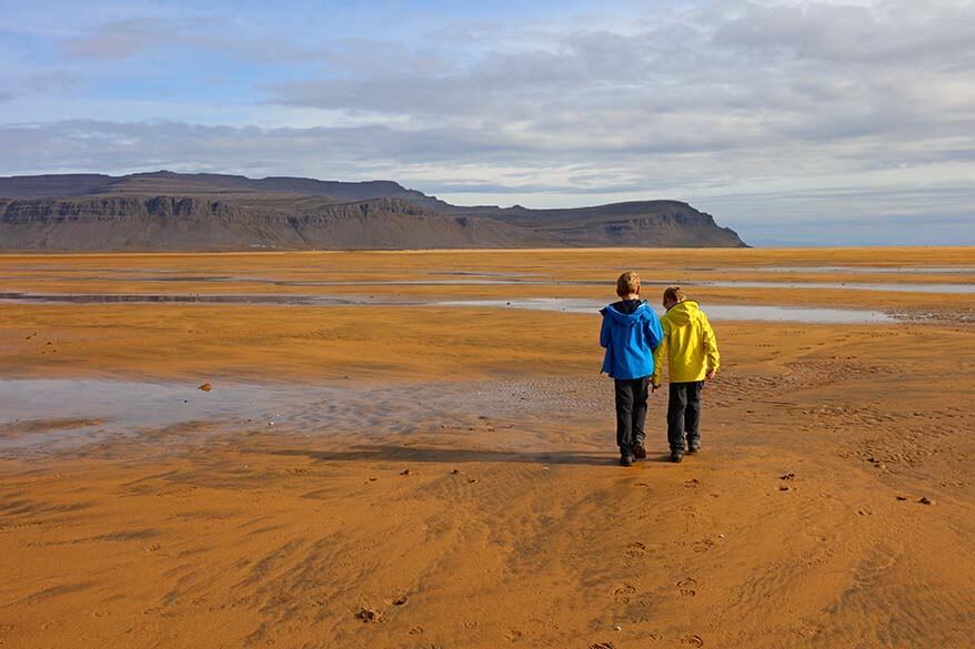 Kids walking on Raudisandur beach in Iceland