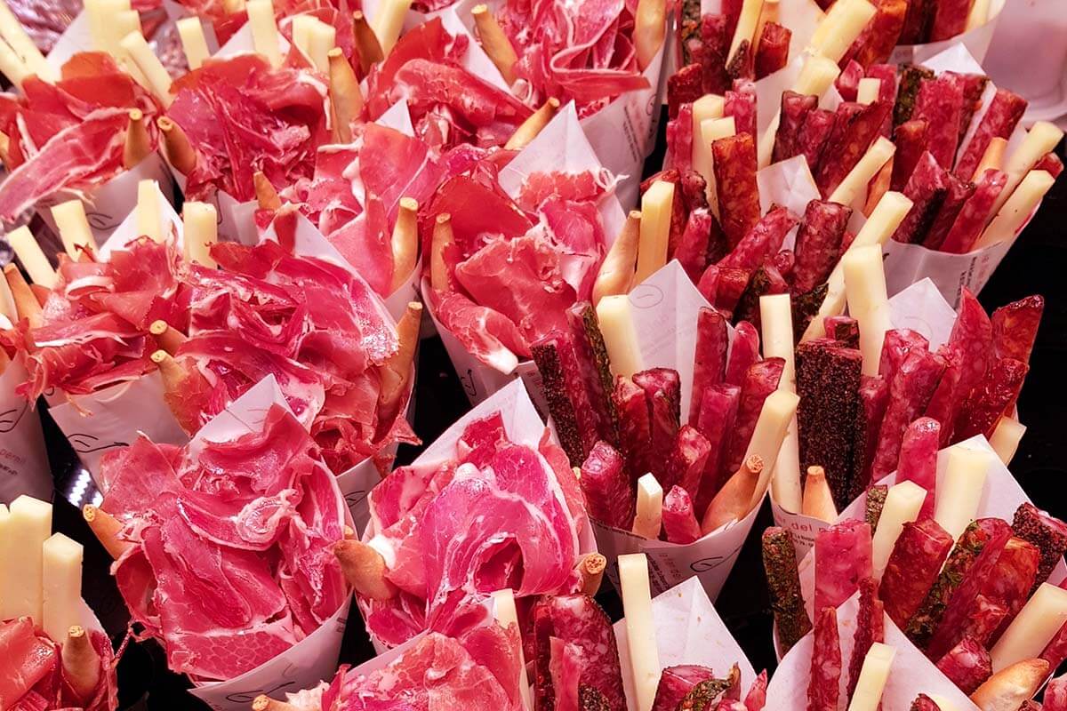 Meat and cheese snacks for sale at Mercado la Boqueria food market in Barcelona