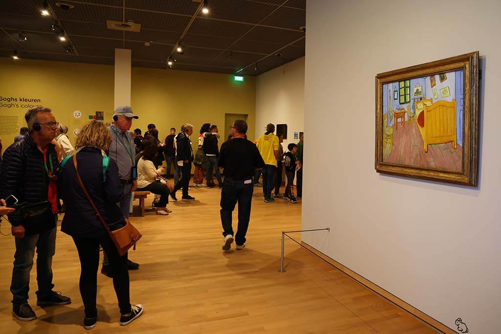 People looking at 'The Bedroom' painting at Van Gogh's Museum in Amsterdam