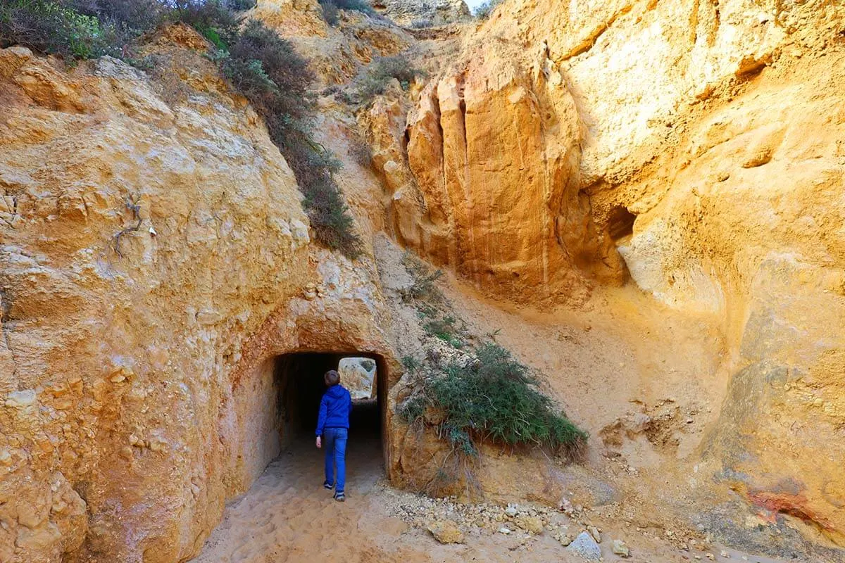 Child walking inside a tunnel on Praia do Camilo in Algarve Portugal