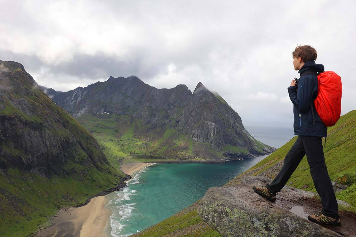 Boy wearing warm clothes and rain jacket in Lofoten in summer