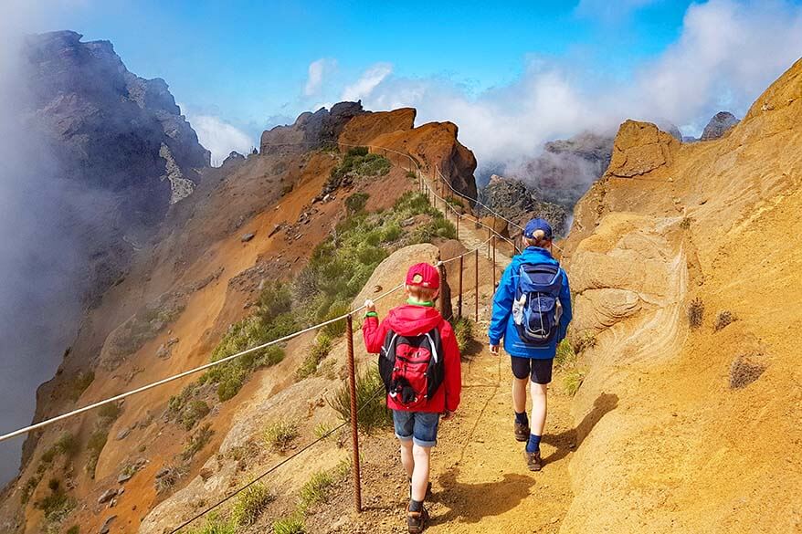 Kids with travel backpacks hiking in the mountains