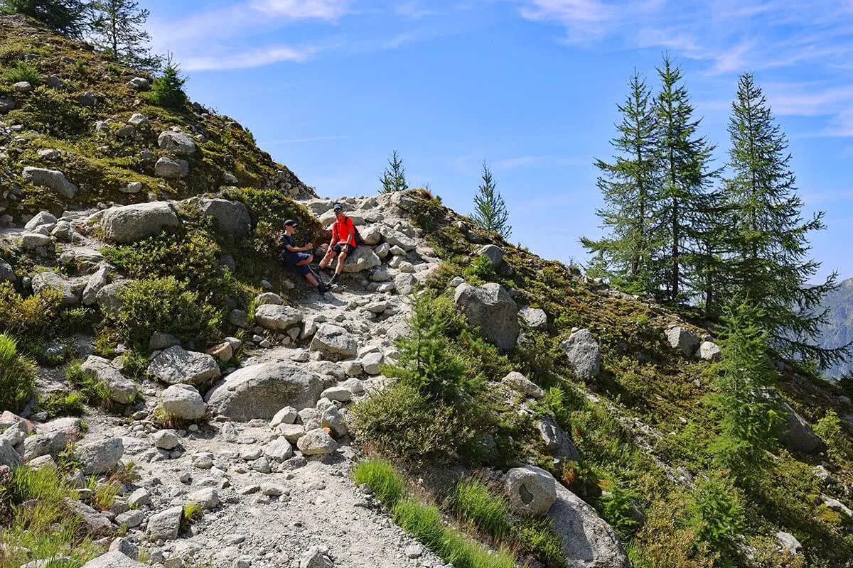 Kids resting on a steep rocky section of Grand Balcon Nord hike in Chamonix